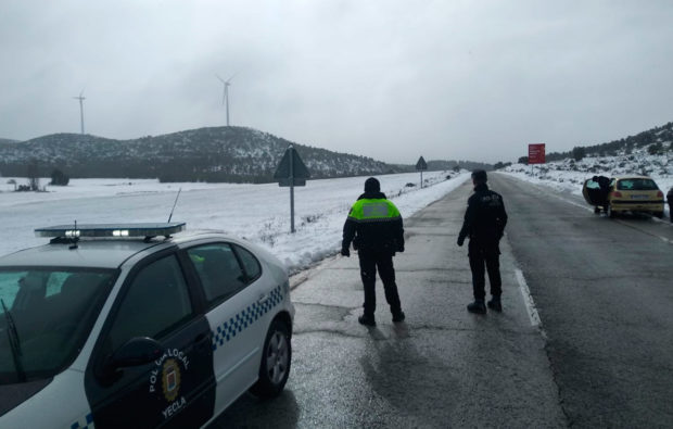 policias en una carretera nevada temporal